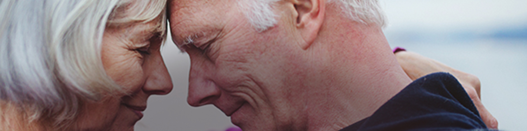 Elderly couple smiling with forehead touching