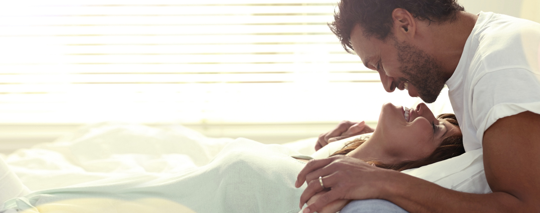 Happy couple kissing in bed